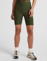 model is wearing green high-waisted 7" inseam biker shorts.